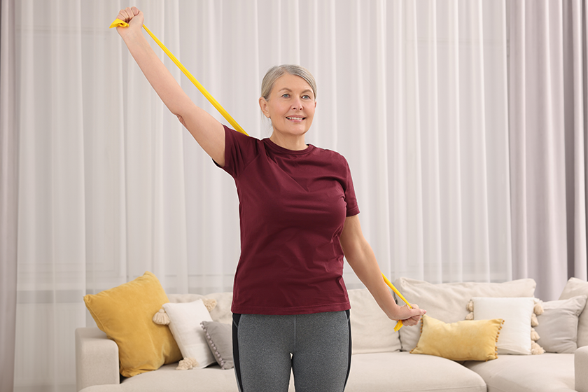 Senior woman doing exercise with fitness elastic band 